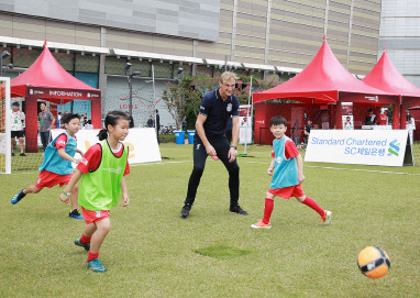 지난 15일 서울 송파구에서 열린 'SC제일은행과 함께하는 리버풀 싸커스쿨'에 참가한 어린이들이 리버풀의 사미 히피아(오른쪽에서 두번째)에게 축구를 배우고 있다. SC제일은행 제공.